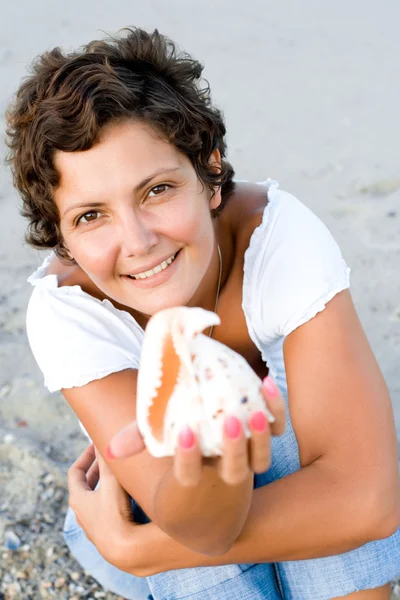 Женщина на берегу моря с петушиным адом в руках — стоковое фото