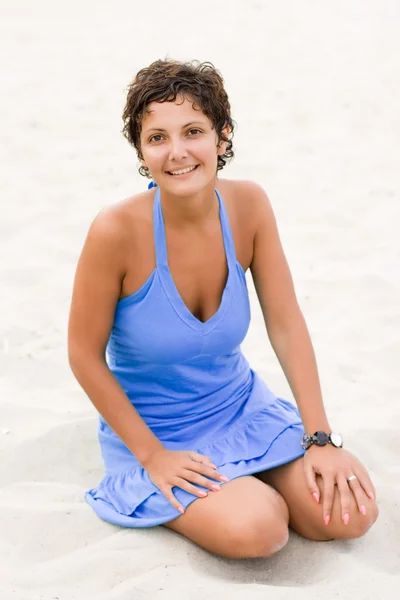 Woman in blue sitting in a sand — Stock Photo, Image