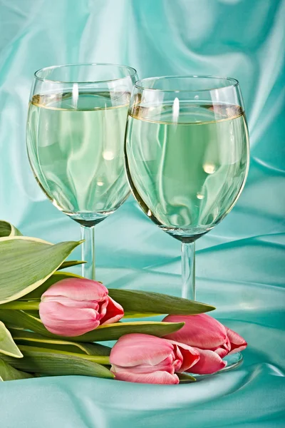 Два бокала белого вина и тюльпаны — стоковое фото