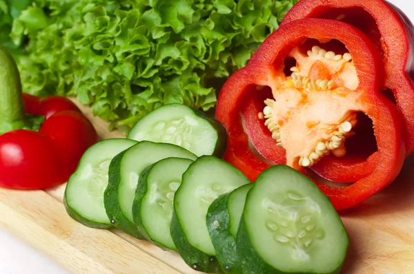 Poivre, salade et concombre sur une planche close up . — Photo