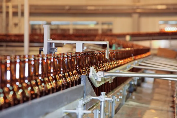 Linea di trasportatori con molte bottiglie di birra — Foto Stock