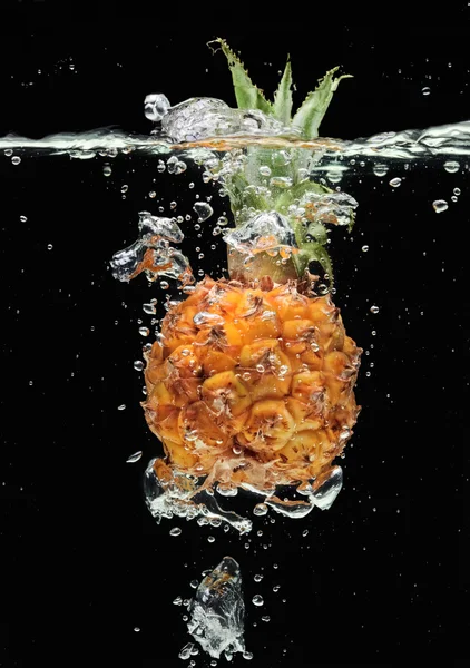 Small pineapple falling in water — Stock Photo, Image