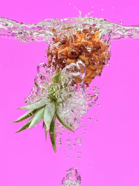 Pequeña piña cayendo en el agua — Foto de Stock