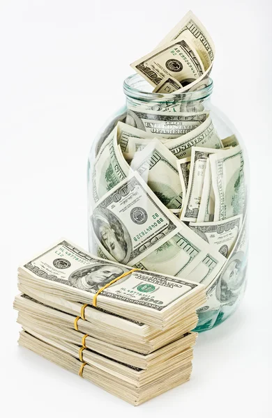 Many 100 US dollars in a glass jar — Stock Photo, Image