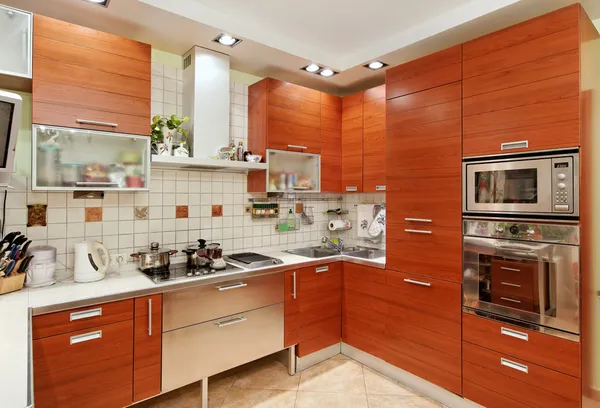 Interiér kuchyně s dřevěným nábytkem a sestavení v nádobí — Stock fotografie