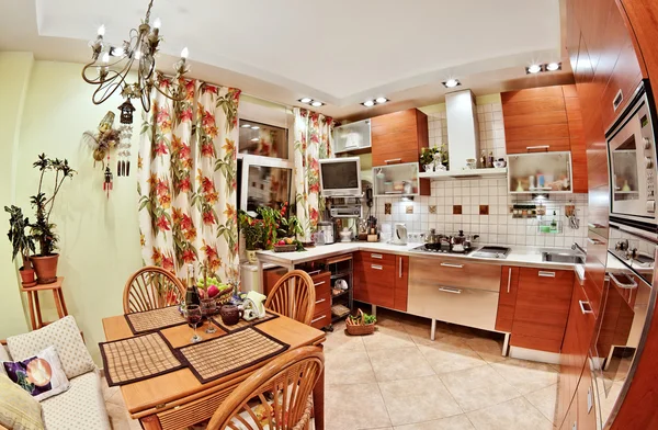 Kücheneinrichtung mit Holzmöbeln, Tisch und vielen Utensilien — Stockfoto