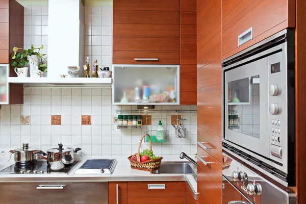 Součástí kuchyňského interiéru s dřevěným nábytkem a sestavení v micr — Stock fotografie