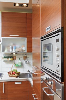 Part of Kitchen interior with wooden furniture and build in micr clipart