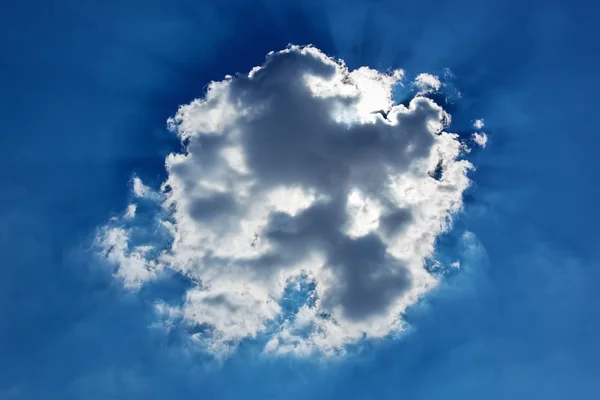Cumulus cloud with sun beams on blue sky background