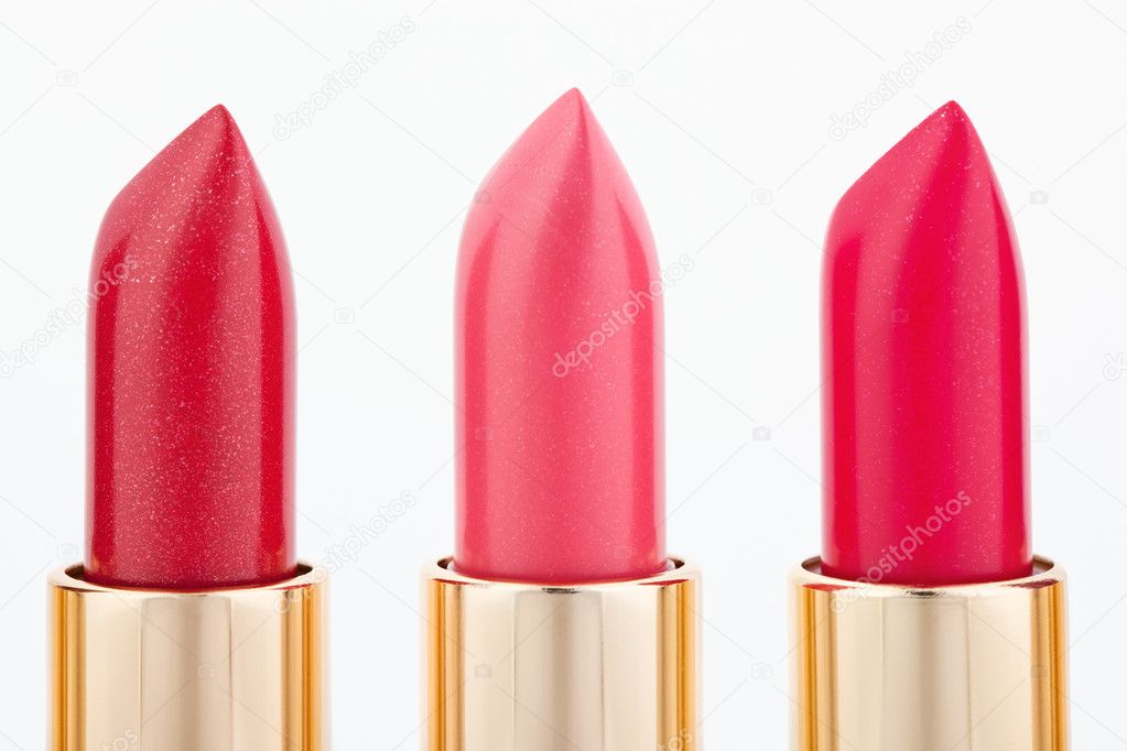 Three color lipsticks arranged in line isolated on white, macro