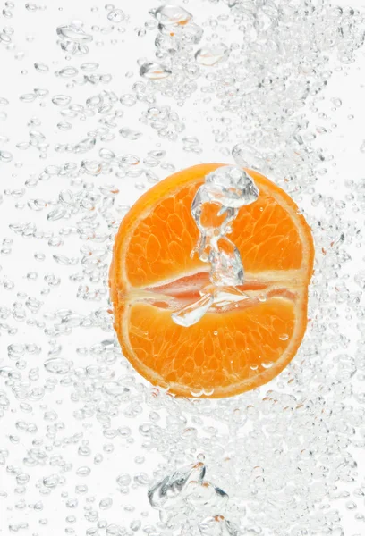 Orange (mandarin) falling in clear water with air bubbles — Stock Photo, Image