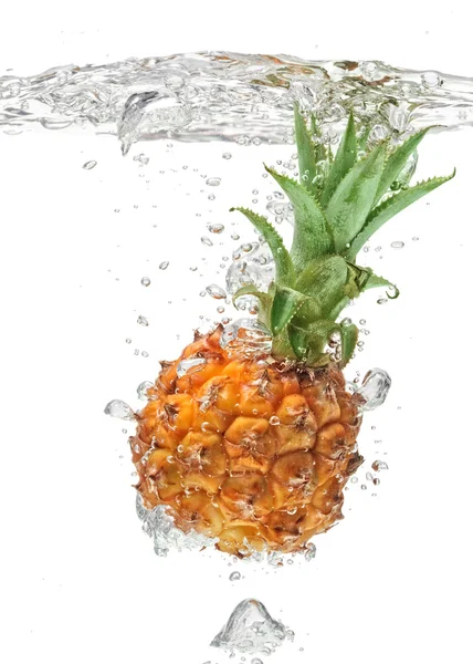 Kleine Ananas fällt ins Wasser auf weiß — Stockfoto