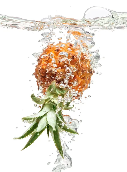 Small pineapple falling in water on white — Stock Photo, Image