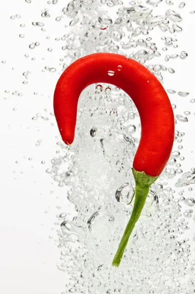 Chilli pepper falling in water with air bubbles — Stock Photo, Image