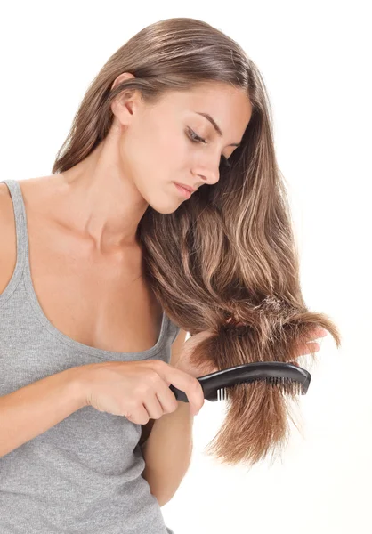 Young brunette beautiful lady combing long hairs on white — Stock Photo, Image