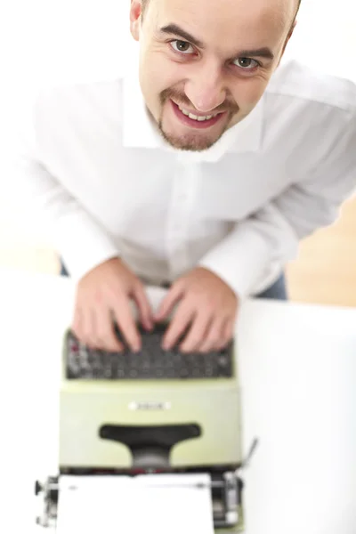 Homme souriant avec machine à écrire vintage Photo De Stock