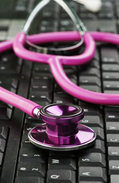 Pink stethoscope on keyboard — Stock Photo, Image