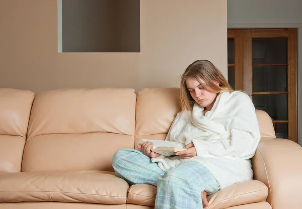 Kvinna läser en bok om soffan — Stockfoto