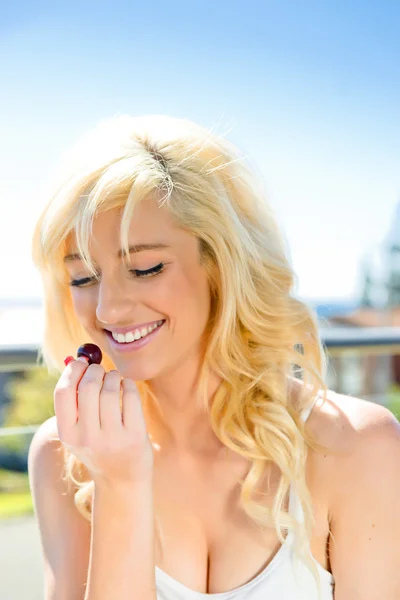 Jovem mulher comendo cereja — Fotografia de Stock