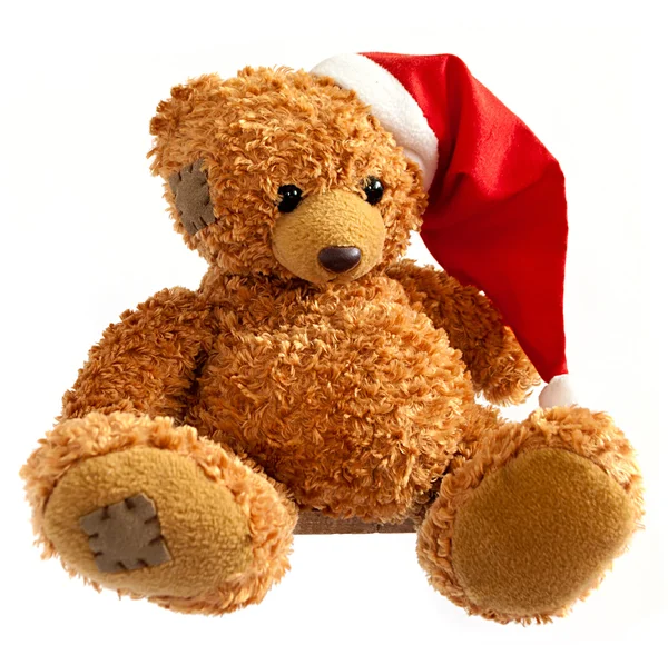 Urso de pelúcia em chapéu de Papai Noel no fundo branco — Fotografia de Stock