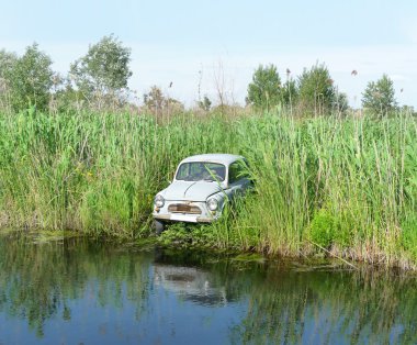 Old car on the river clipart