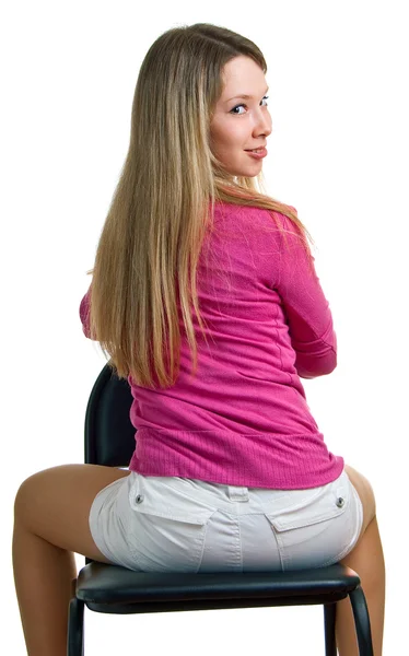 Leende flicka sitter på en stol — Stockfoto