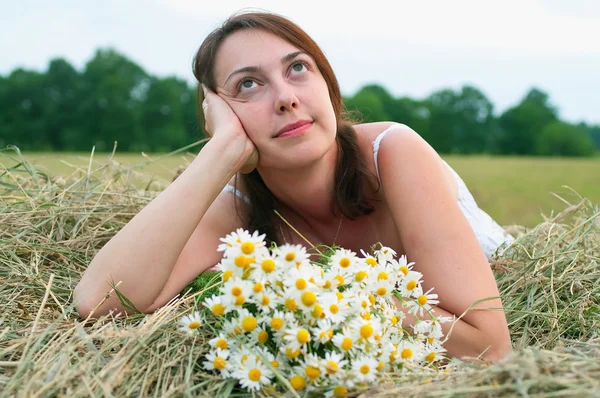 Flicka med chamomiles på höstacken — Stockfoto