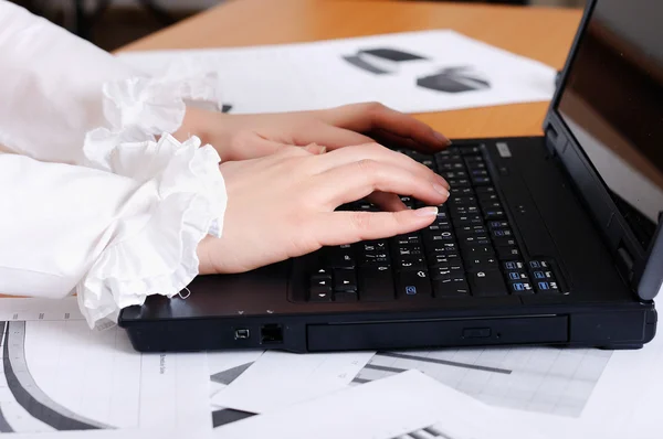 Handen van een jong meisje die op laptop werkt — Stockfoto