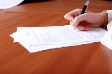 Person's hand signing document clipart