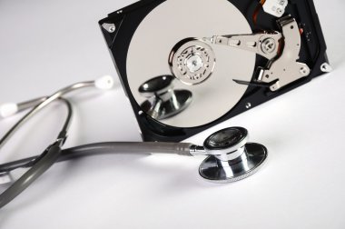 Computer hard drive and a stethoscope. clipart