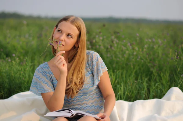 Yeşil çimenlerin üzerinde oturan kız — Stok fotoğraf