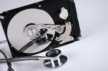 Computer hard drive and a stethoscope. clipart