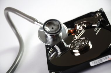 Computer hard drive and a stethoscope. clipart