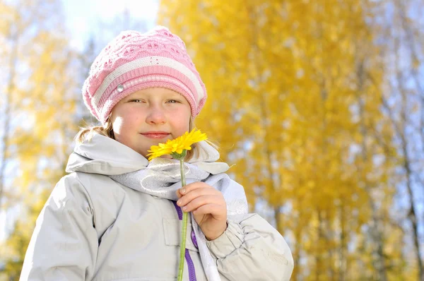 Petite fille avec une fleur jaune — Photo