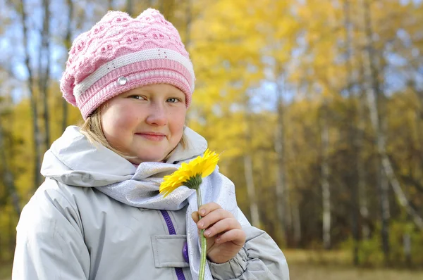 Petite fille avec une fleur jaune — Photo