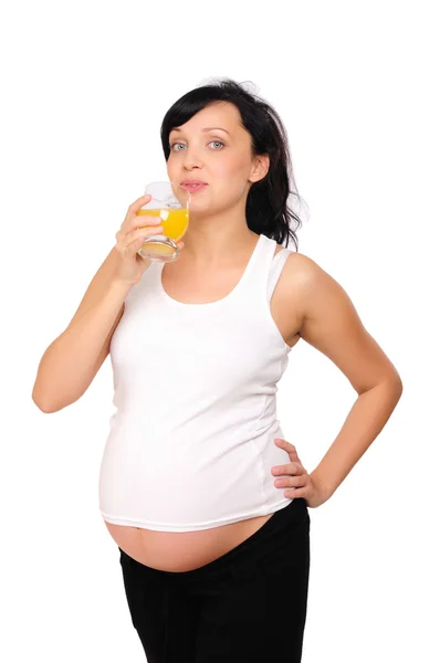 Молода вагітна жінка п'є апельсин — стокове фото