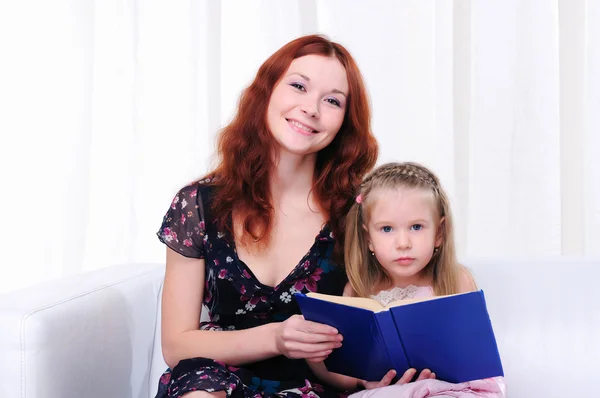 Liten flicka och hennes mamma läsa en bok — Stockfoto