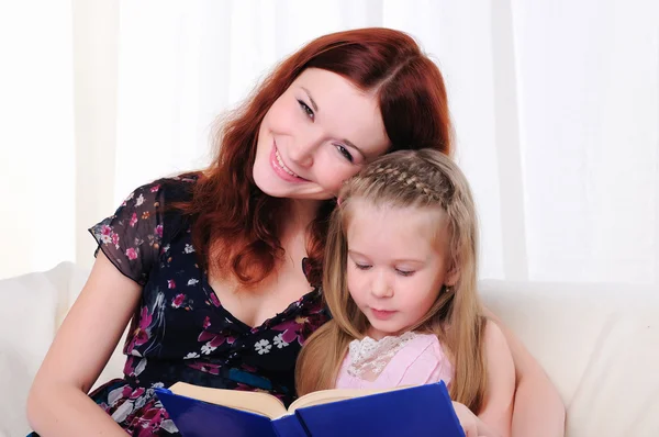 Маленькая девочка и ее мать читали книгу — стоковое фото