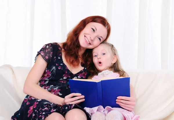 Liten flicka och hennes mamma läsa en bok — Stockfoto