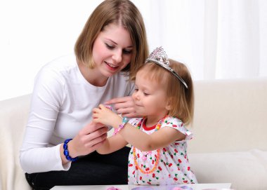 Young mother and her baby daughter clipart