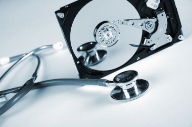 Computer hard drive and a stethoscope. clipart