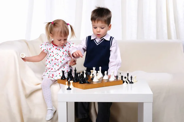 Erkek ve kız kardeş satranç oynuyor. — Stok fotoğraf