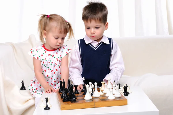 Erkek ve kız kardeş satranç oynuyor. — Stok fotoğraf