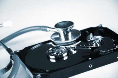 Computer hard drive and a stethoscope. clipart