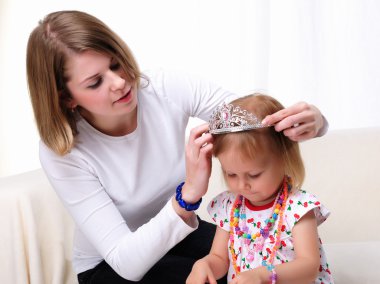 Young mother and her baby daughter clipart