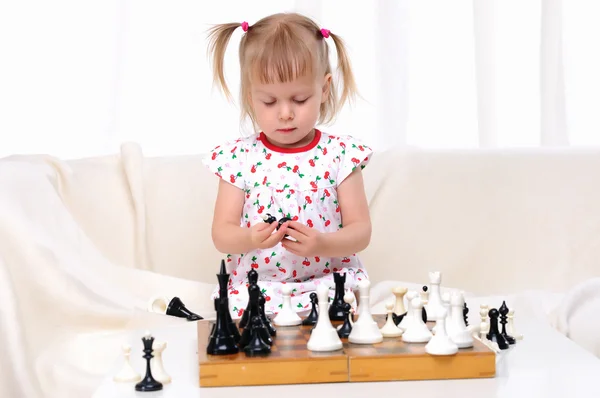 Маленькая девочка играет в шахматы — стоковое фото