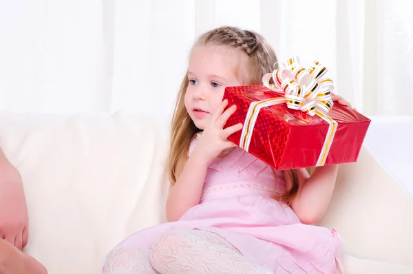 Little girl give a holiday gift Royalty Free Stock Images