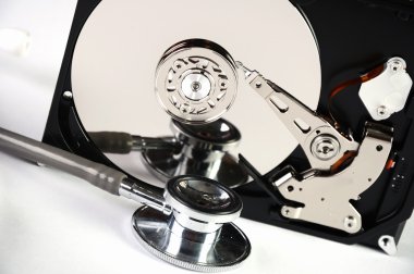 Computer hard drive and a stethoscope. clipart