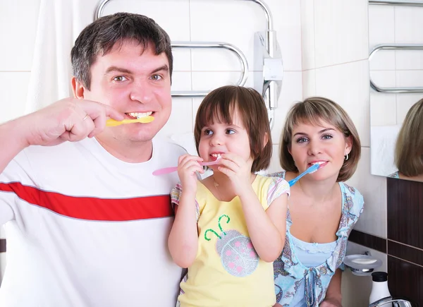 Mom, daughter and father brush their teeth — Stock Photo, Image