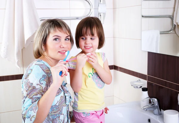 Anne ve kızı dişlerini fırçalama — Stok fotoğraf